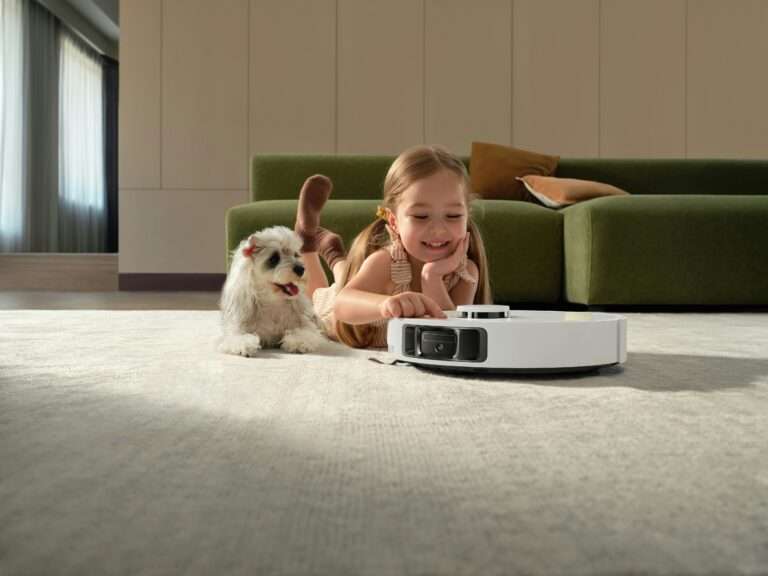 Autonomous robot vacuum cleaner cleaning carpet in modern living room with child and pet dog