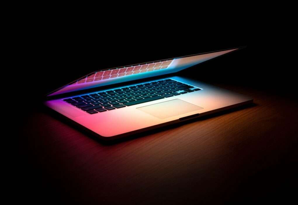 dark background and a laptop partially close